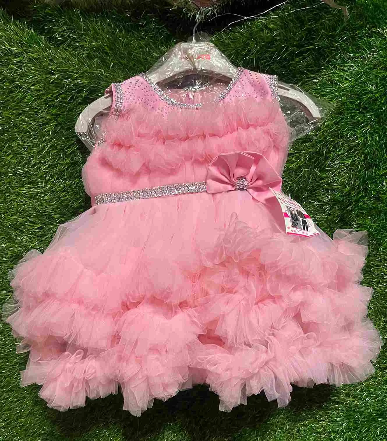 Pink layered tulle gown with rhinestone neckline and bow waistband